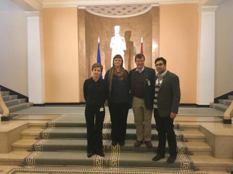 Linda Austere in the Latvian government building, with Inese Voika, Mike Smith and Rishabh Khanna, in front of the statue which is the Latvian symbol of Justice